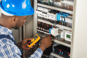 Electrician Checking Fuse Box With Multimeter