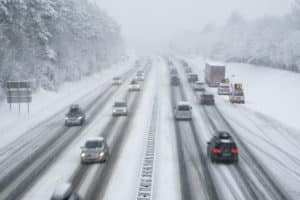 snow covered highway with cars