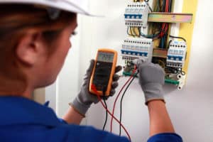 Female electrician checking a fusebox